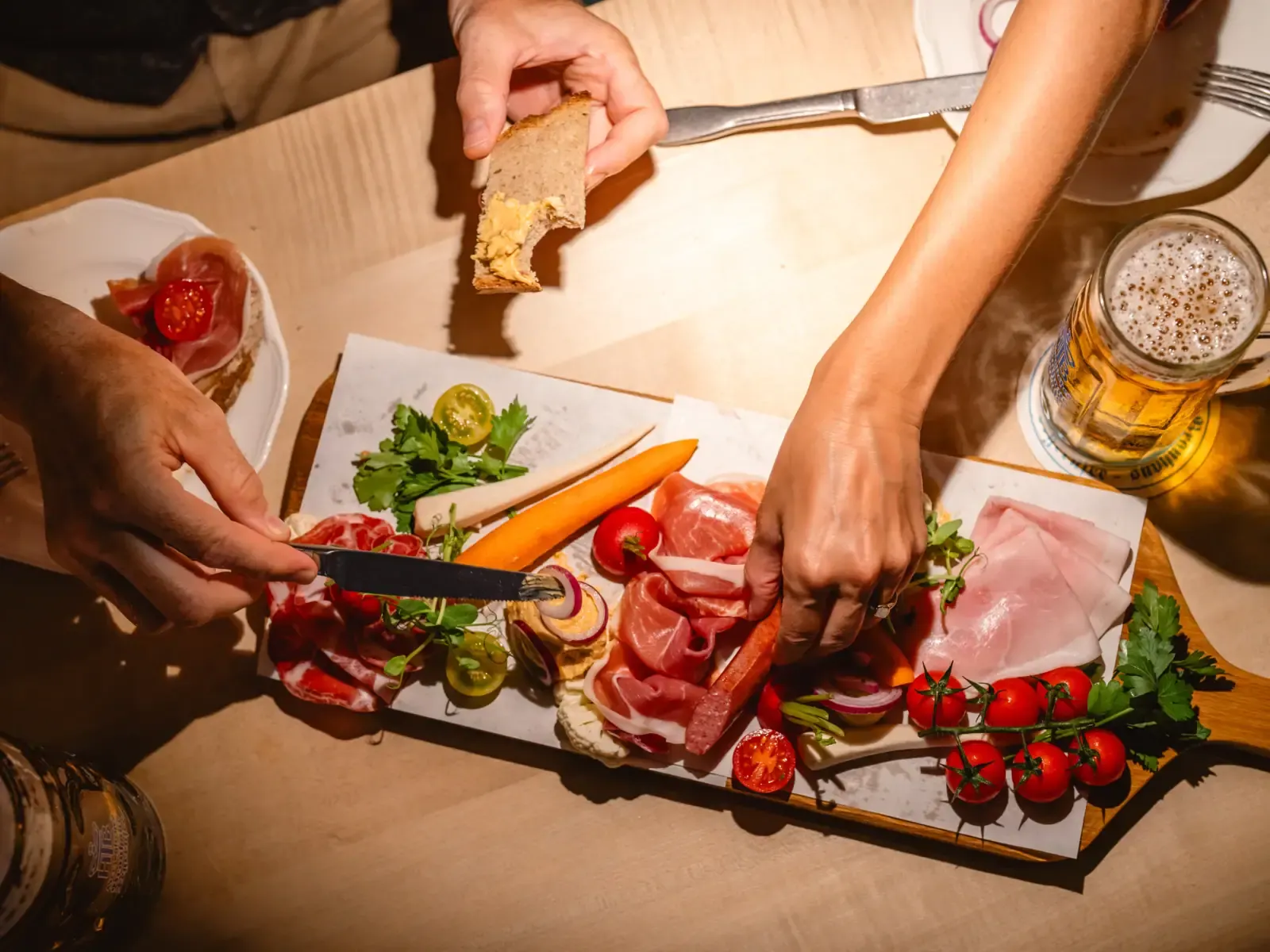 Bayerische Brotzeitplatte mit Wurst, Käse, Tomaten und Bier von oben fotografiert