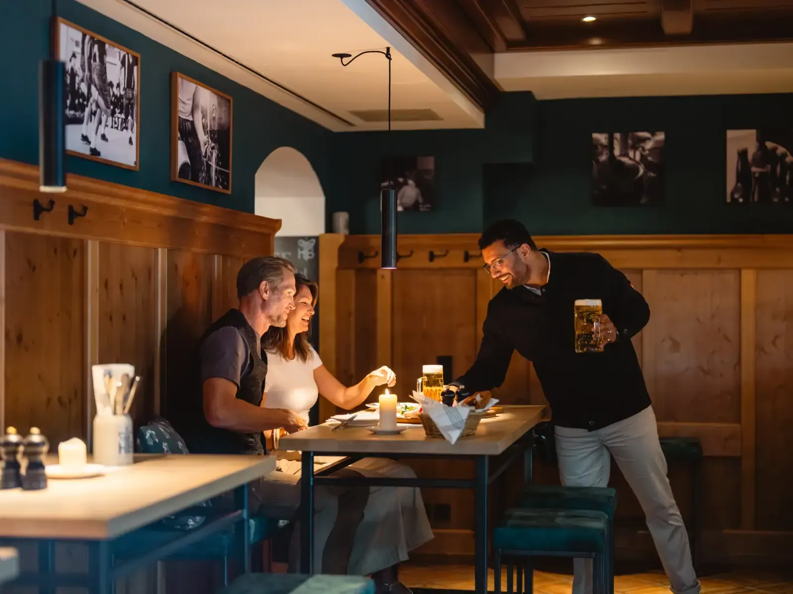 Kellner serviert frisch gezapftes Bier an einem Tisch im gemütlichen Restaurant des Wirtshaus in Binz
